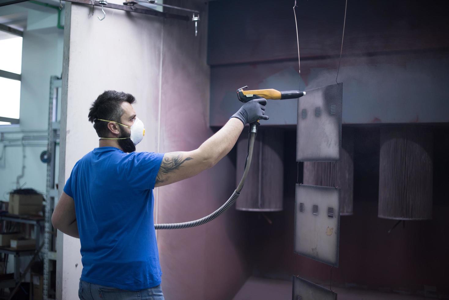 le peintre peint l'élément de fer. pièces de peinture industrielle. dessins en métal photo