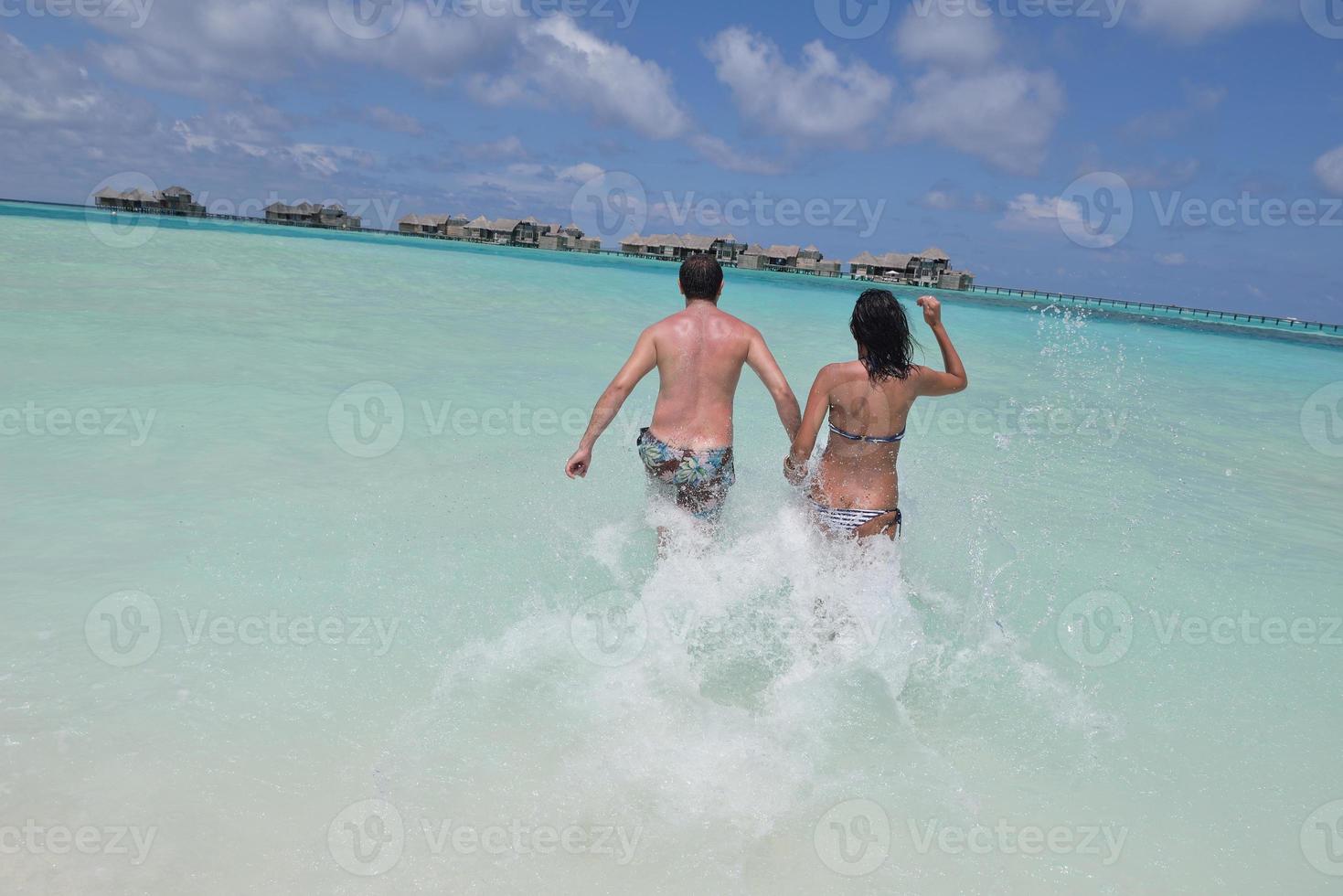 heureux jeune couple s'amuser sur la plage photo