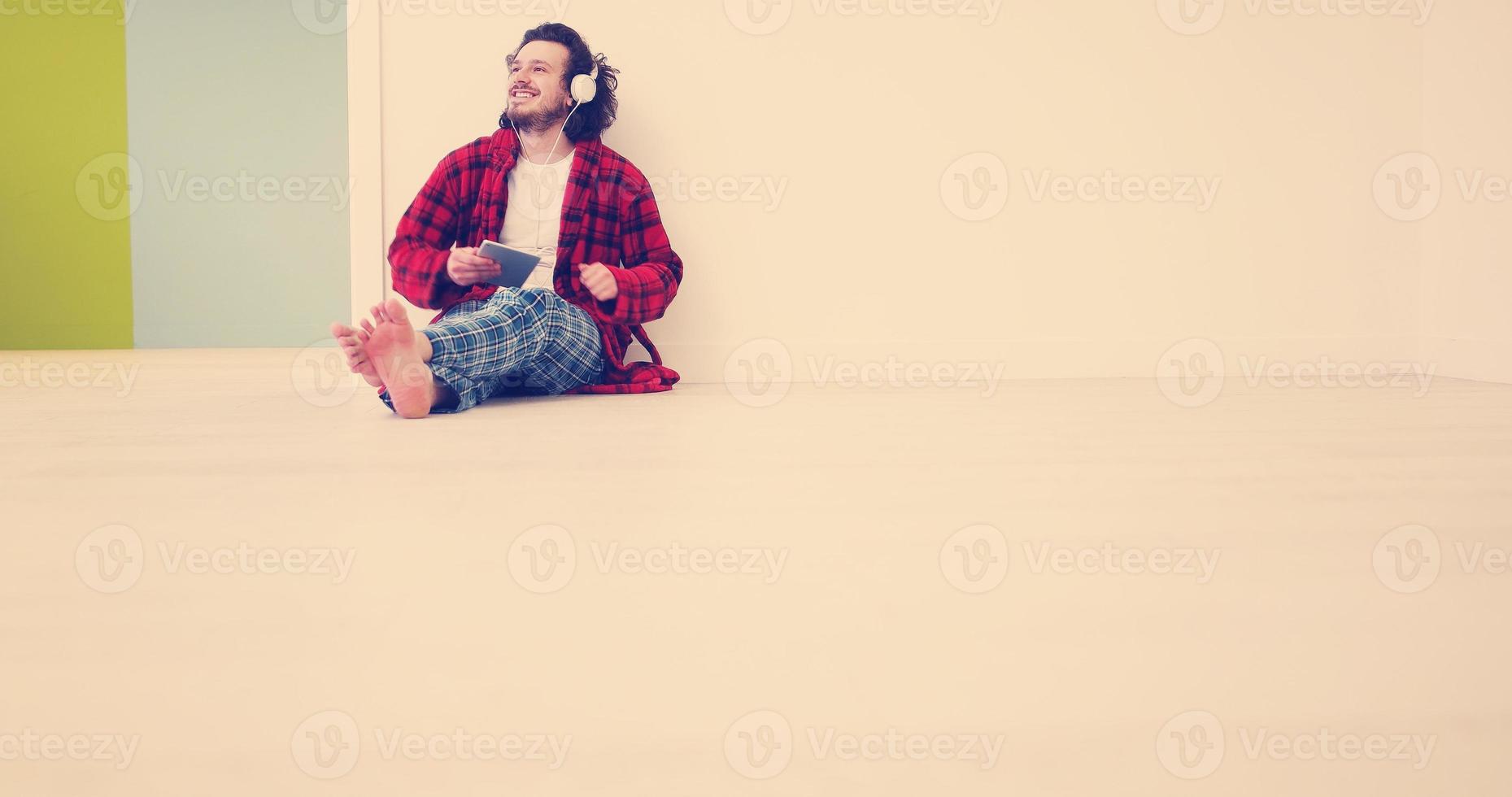 jeune homme écoute de la musique sur tablette à la maison photo