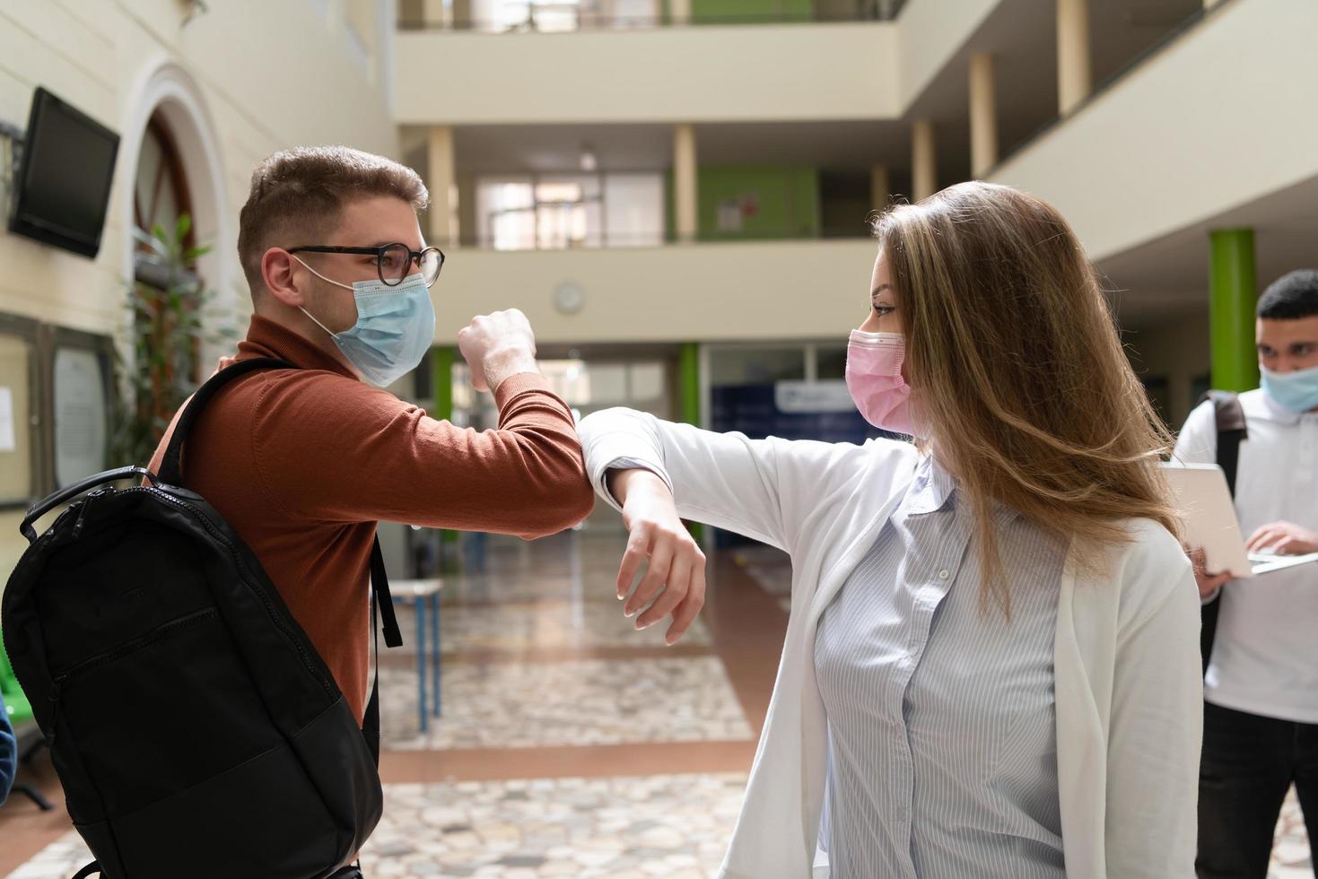 les étudiants saluent une nouvelle poignée de main normale contre le coronavirus et se cognent le coude photo