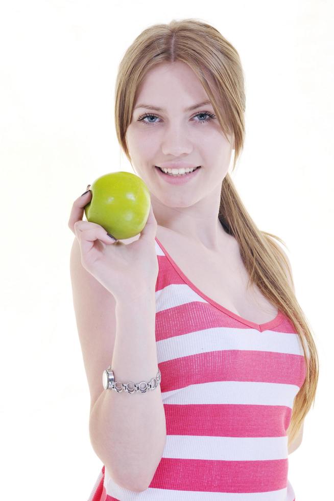 heureuse jeune femme mange une pomme verte isolée sur blanc photo