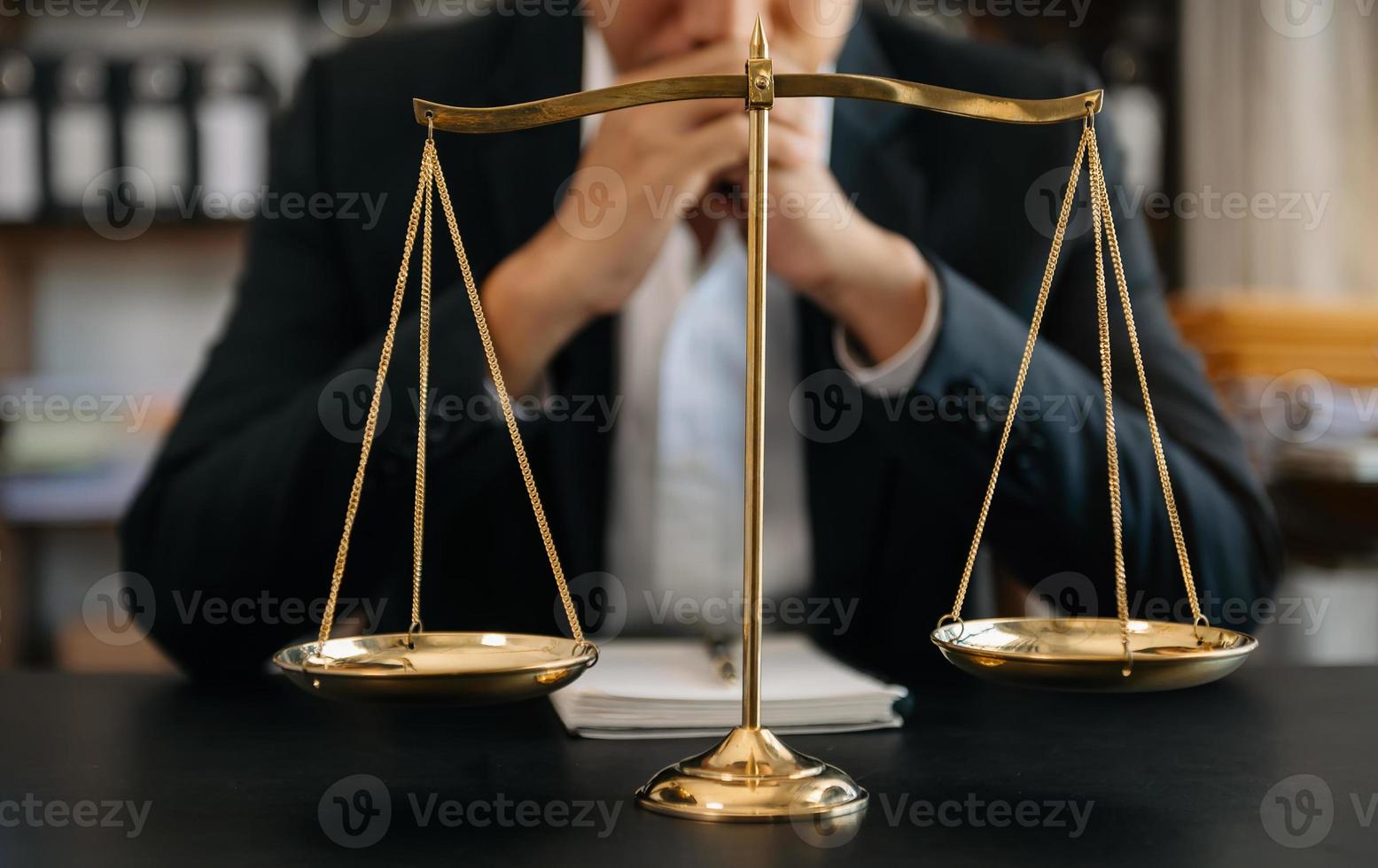 avocat masculin au bureau avec échelle en laiton sur table en bois. concept de justice et de droit à la lumière du matin photo