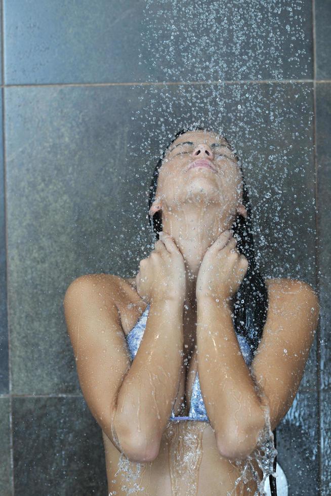 sexy jeune femme enjoing bain sous douche d'eau photo