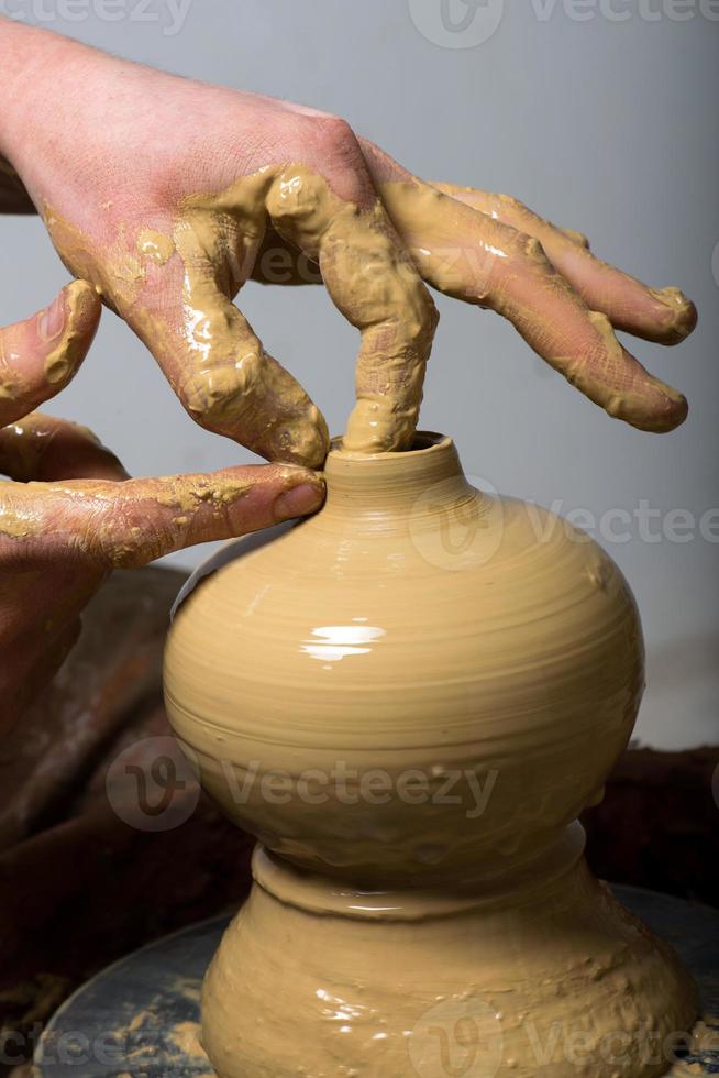 mains d'un potier, créant un pot en terre photo