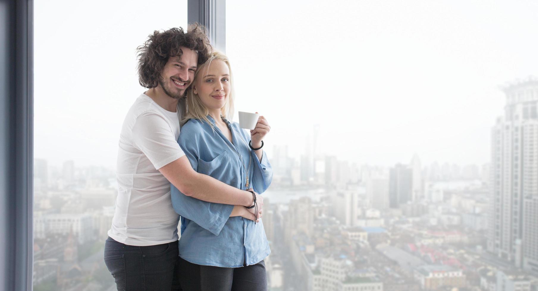 jeune couple appréciant le café du matin près de la fenêtre photo