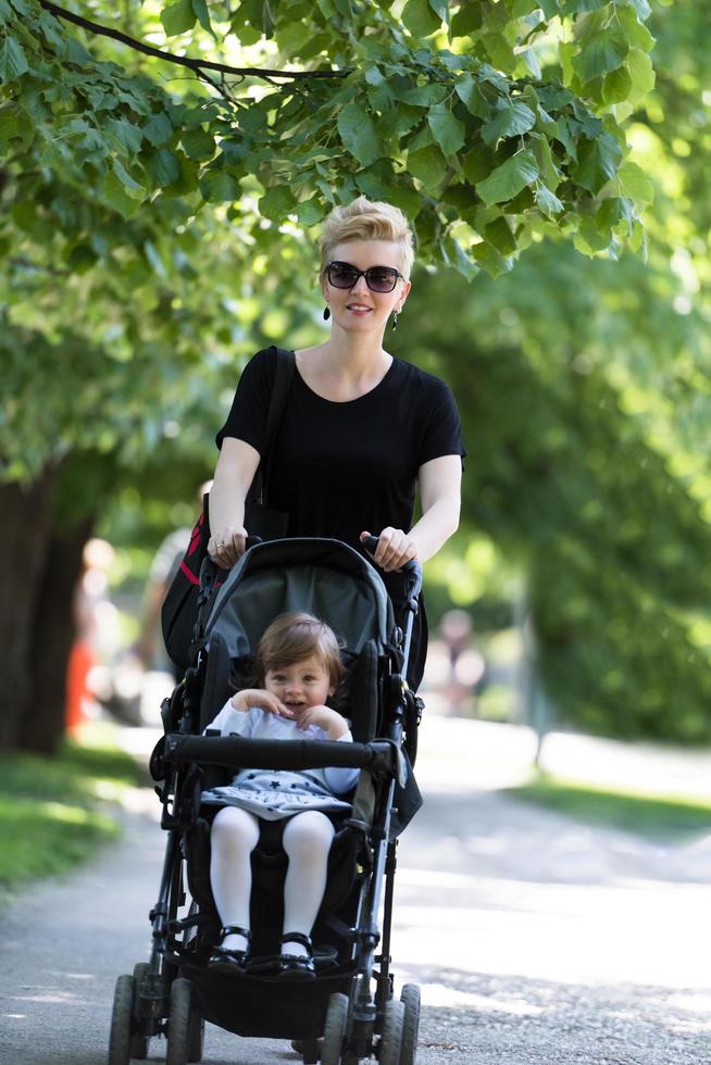 mère a poussé sa petite fille dans une poussette photo