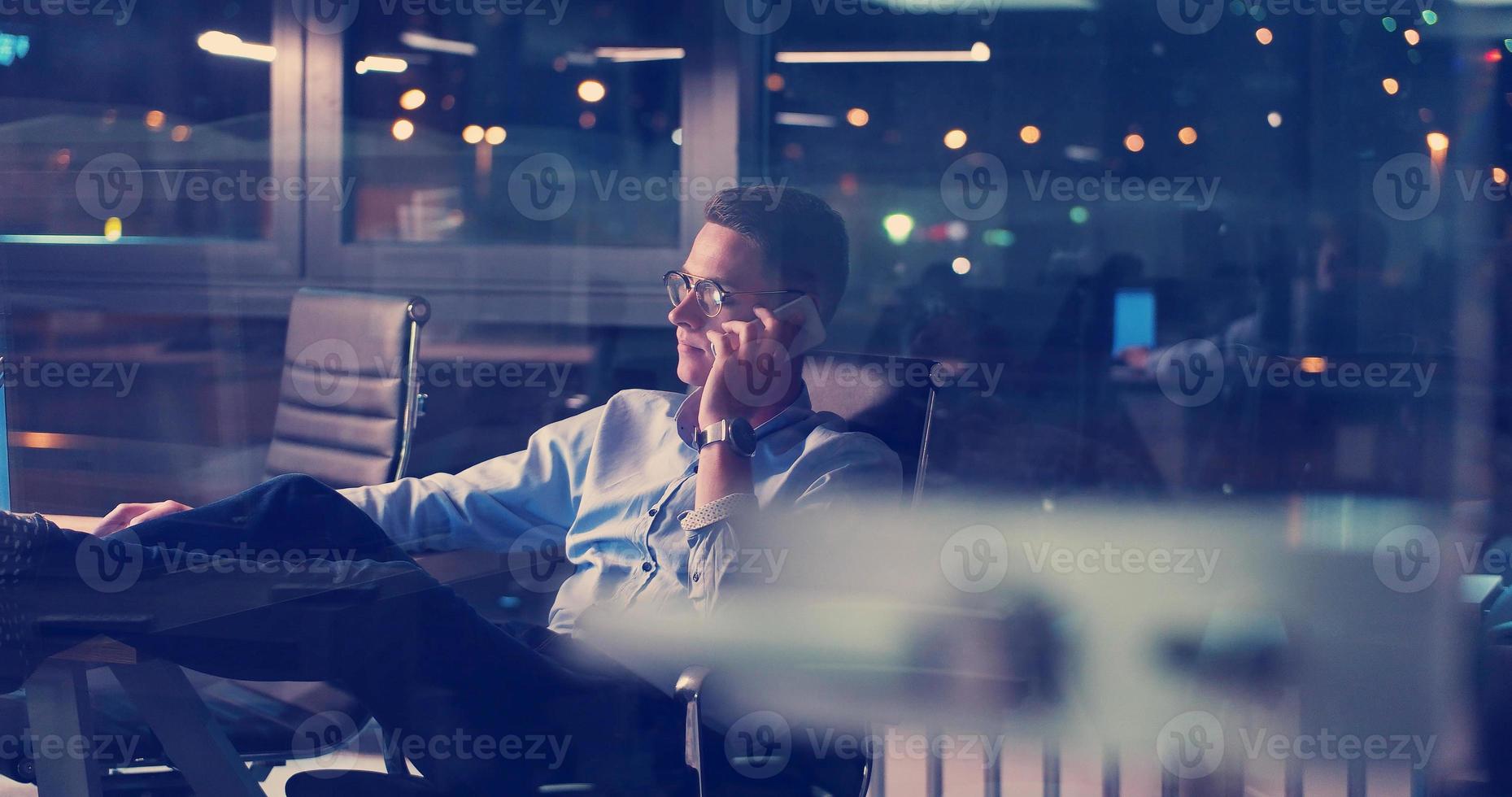 homme d'affaires assis avec les jambes sur le bureau au bureau photo