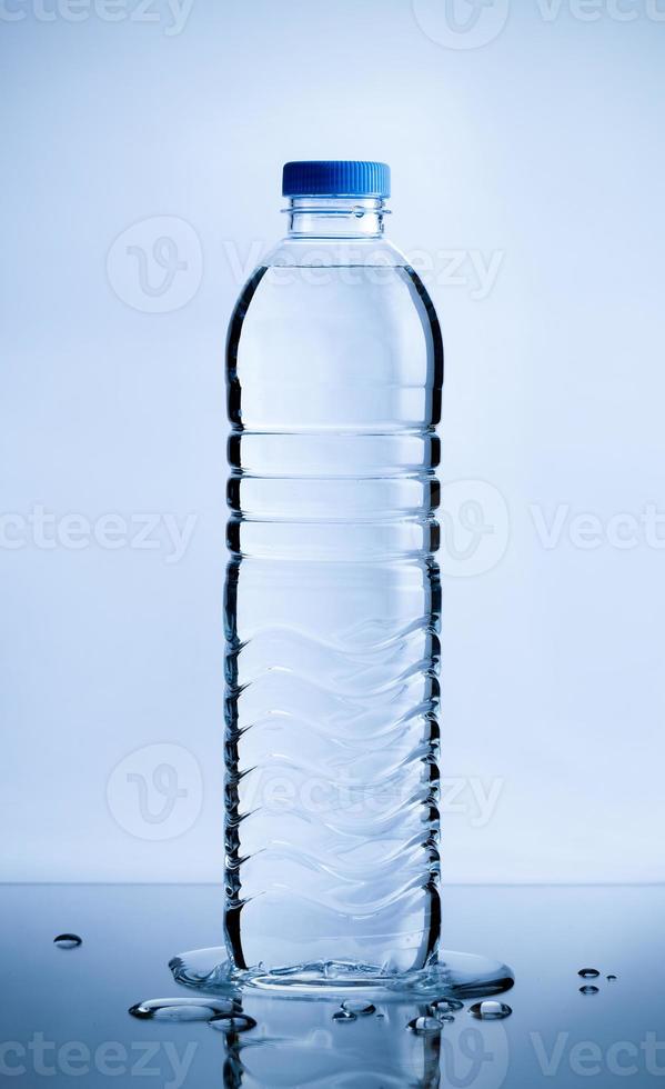 bouteille d'eau pure en plastique avec des gouttes d'eau sur la table, concept d'hydratation de soins de santé et de beauté photo