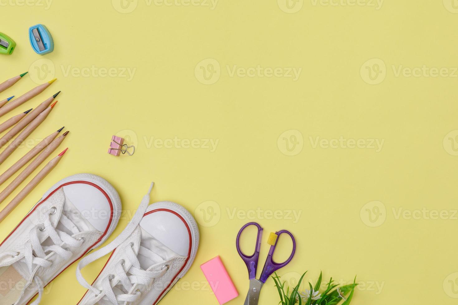 flatlay créatif de l'éducation table jaune avec chaussures, crayon coloré, espace vide isolé sur fond jaune, concept d'éducation et retour à l'école photo