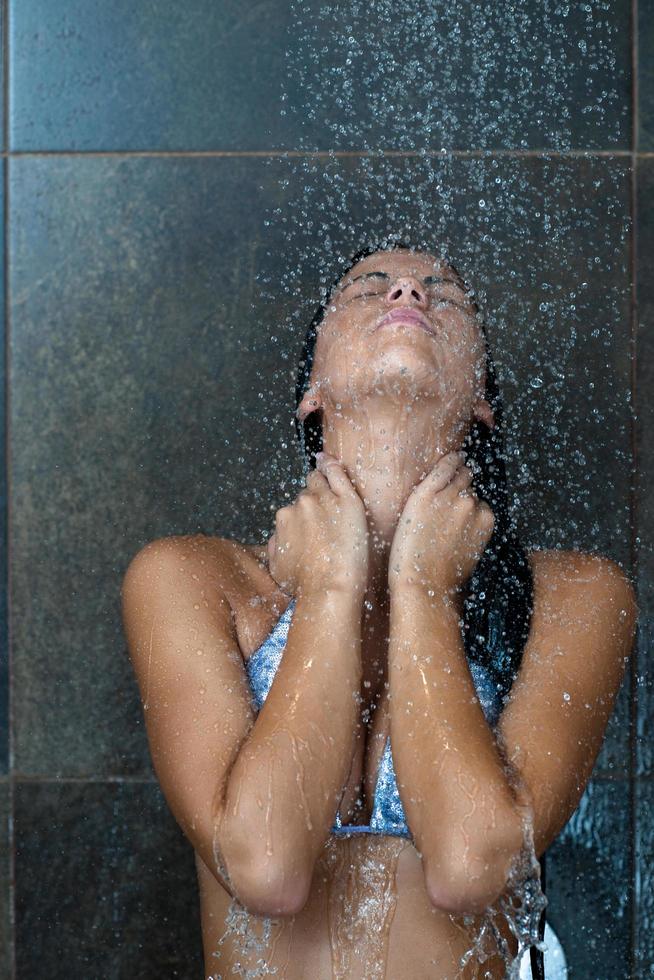 sexy jeune femme enjoing bain sous douche d'eau photo