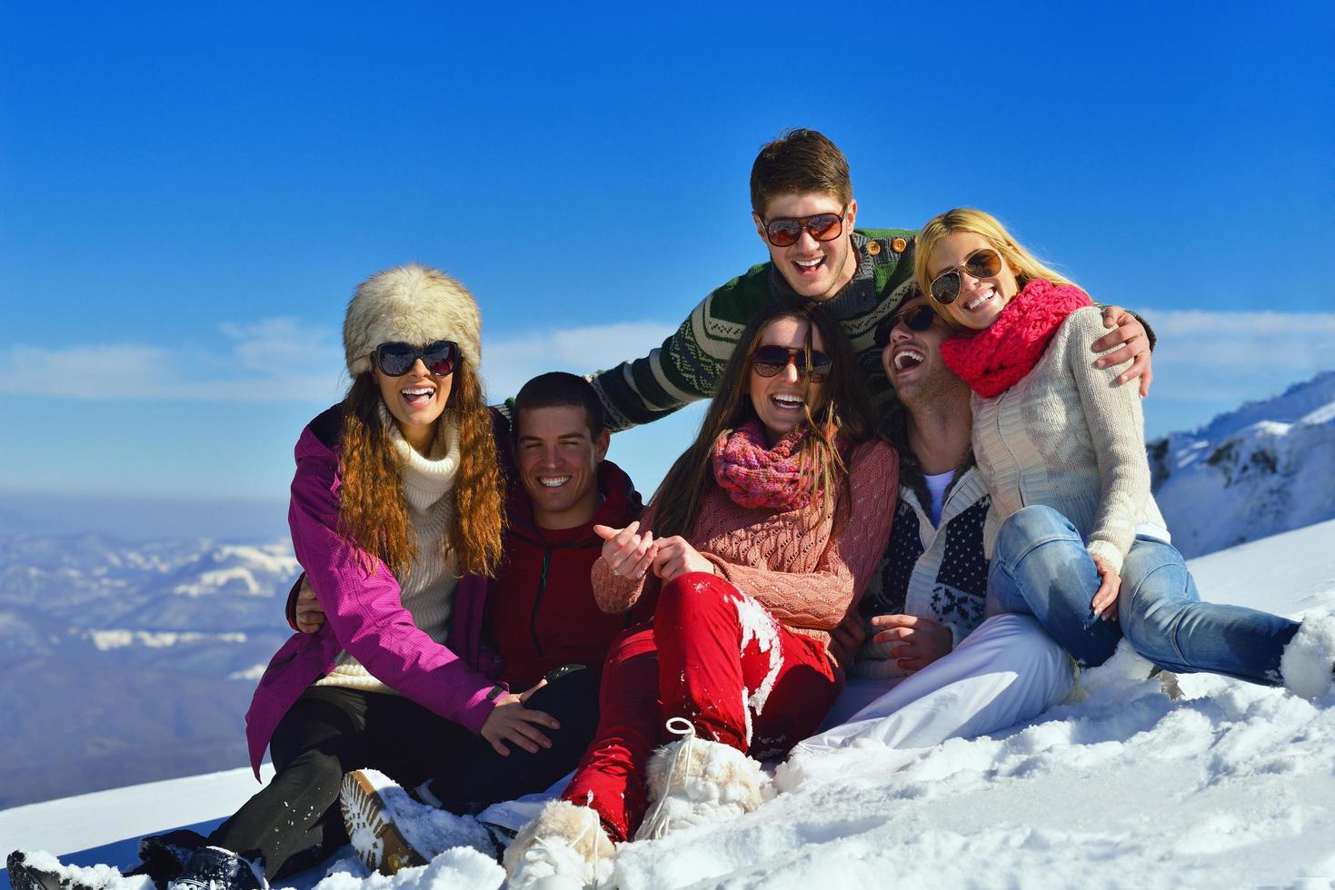 les amis s'amusent en hiver sur la neige fraîche photo