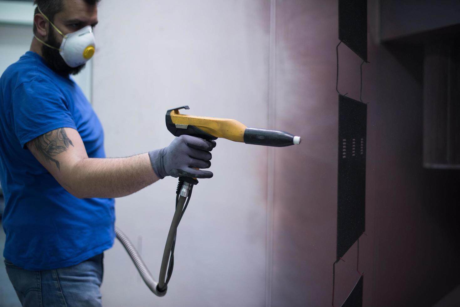 le peintre peint l'élément de fer. pièces de peinture industrielle. dessins en métal photo