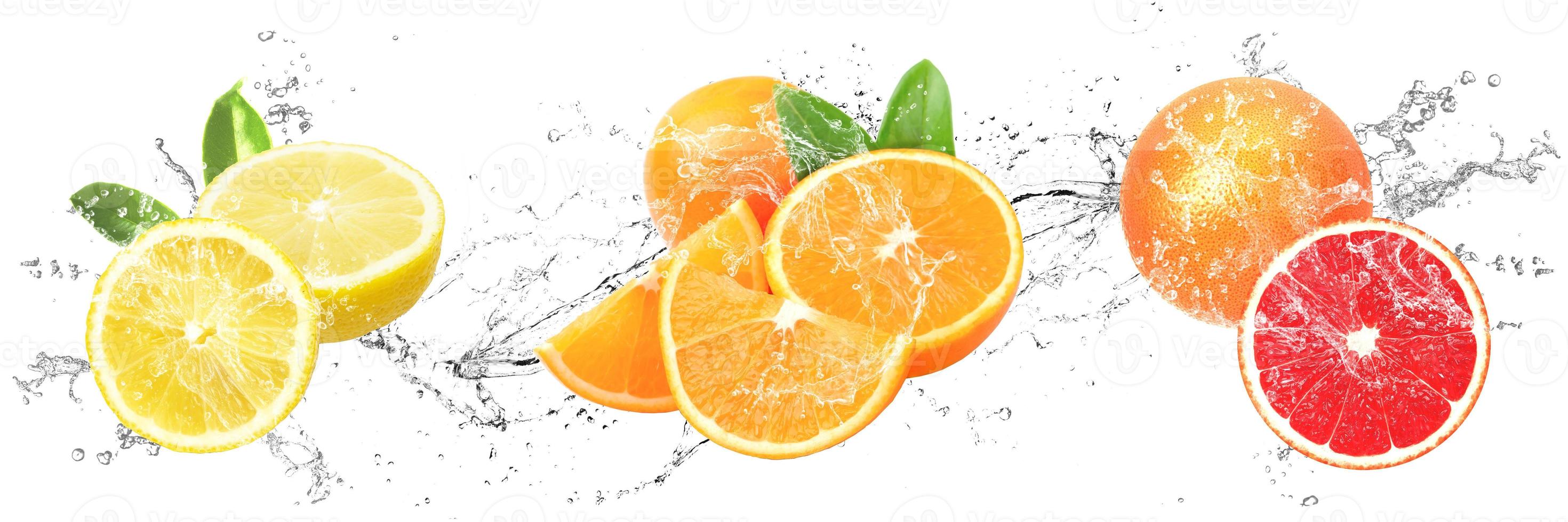 fruits frais avec des éclaboussures d'eau sur fond blanc isolé. citron, orange et pamplemousse photo