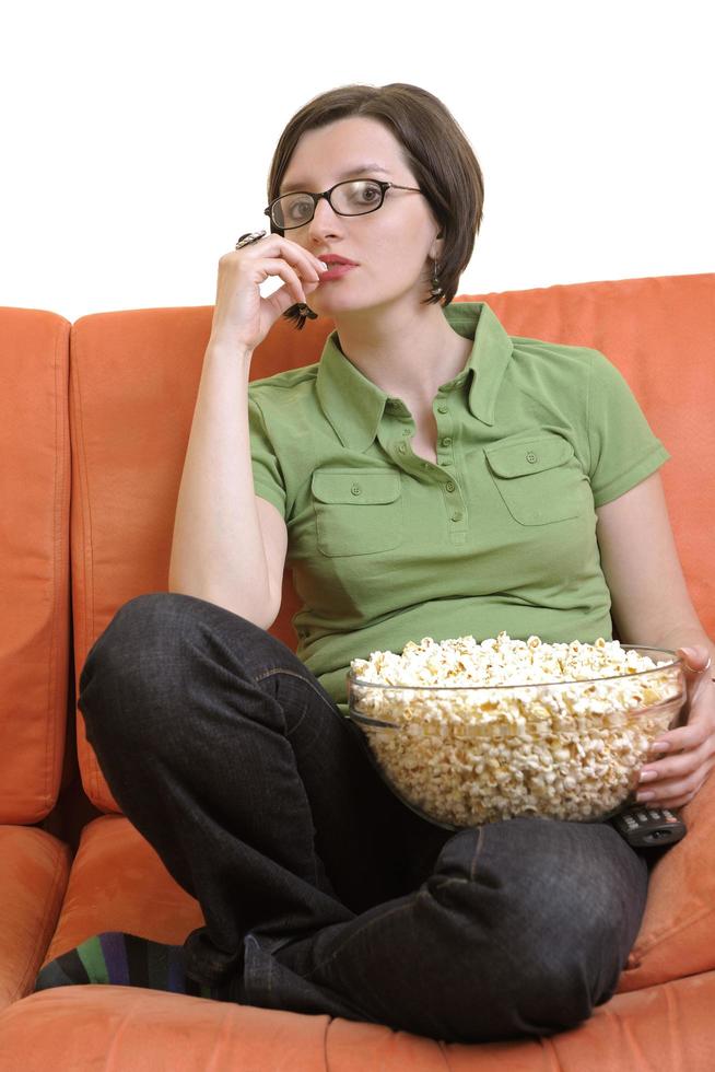 jeune femme manger du pop-corn et regarder la télévision photo