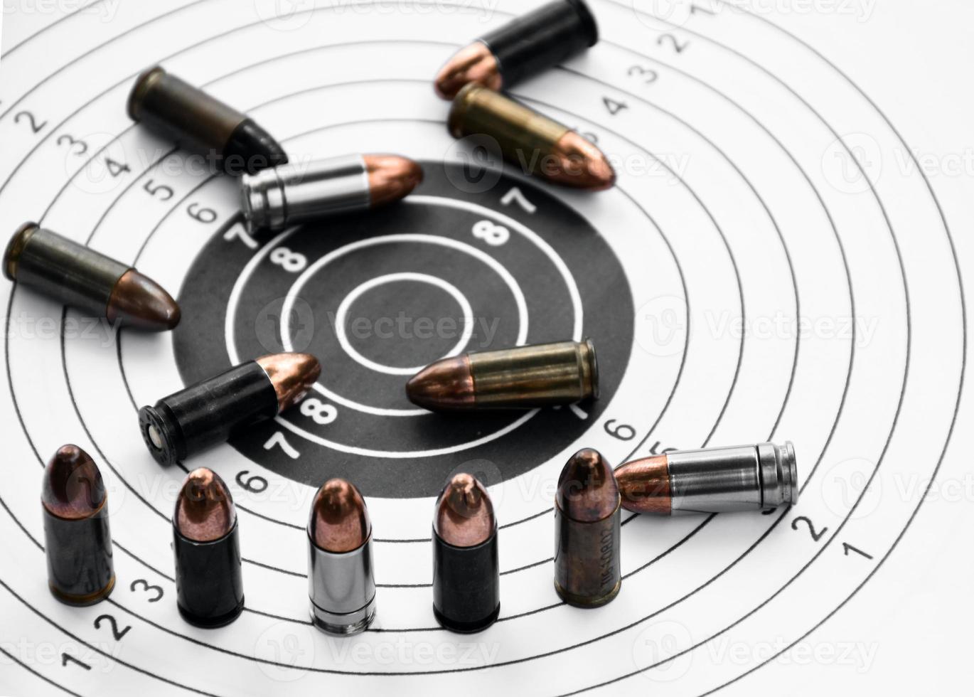 Balles de pistolet de 9 mm et obus de balle sur papier cible de tir, mise au point douce et sélective. photo