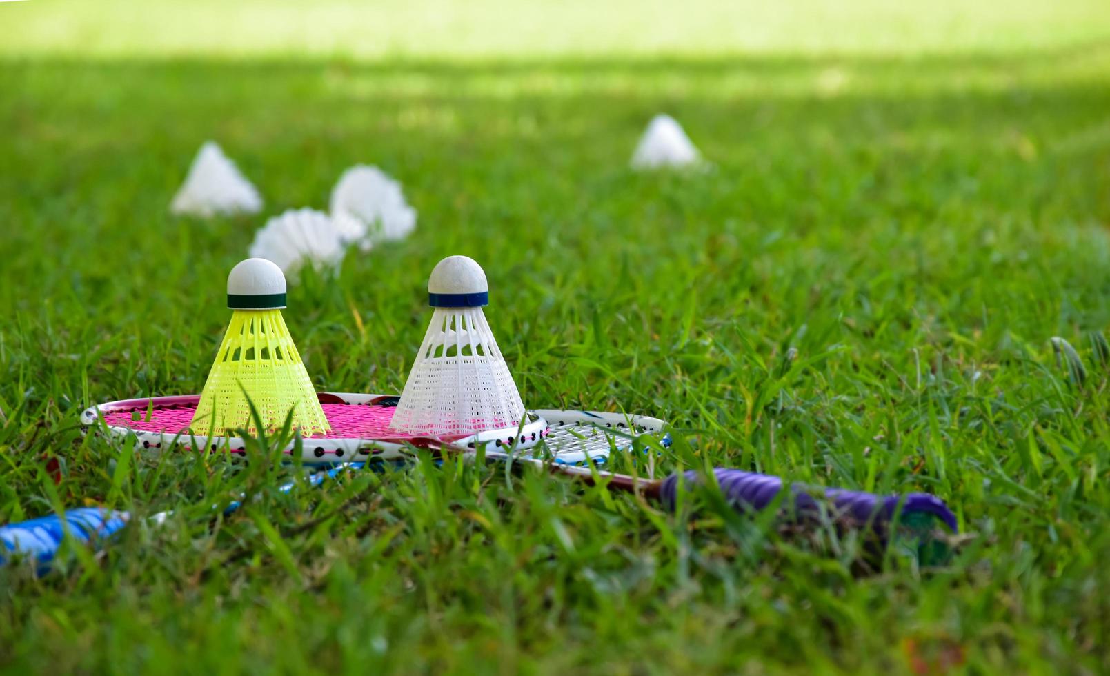 équipements de badminton en plein air volants et raquettes de badminton, sur pelouse, mise au point douce et sélective sur les volants, concept de jeu de badminton en plein air photo