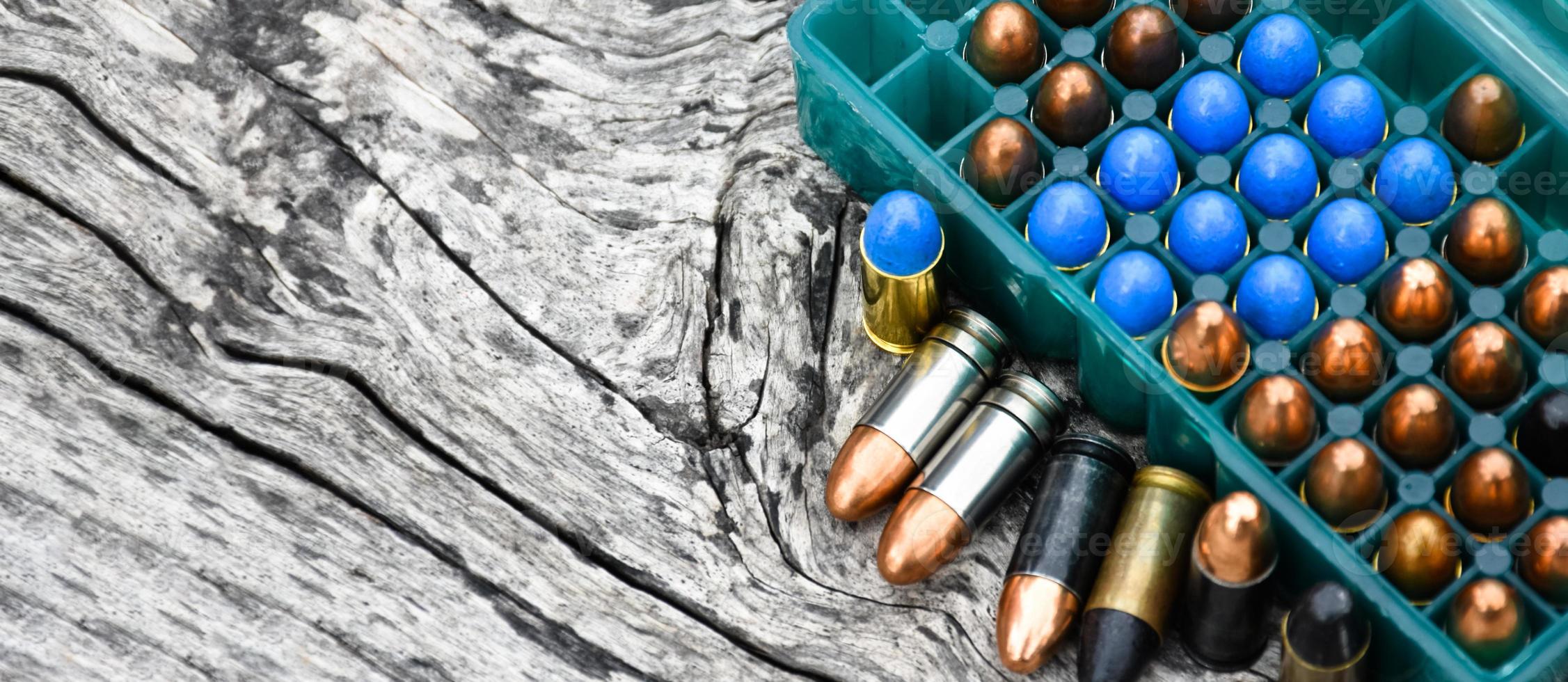 Balles de pistolet de 9 mm et obus de balle sur table en bois, mise au point douce et sélective. photo