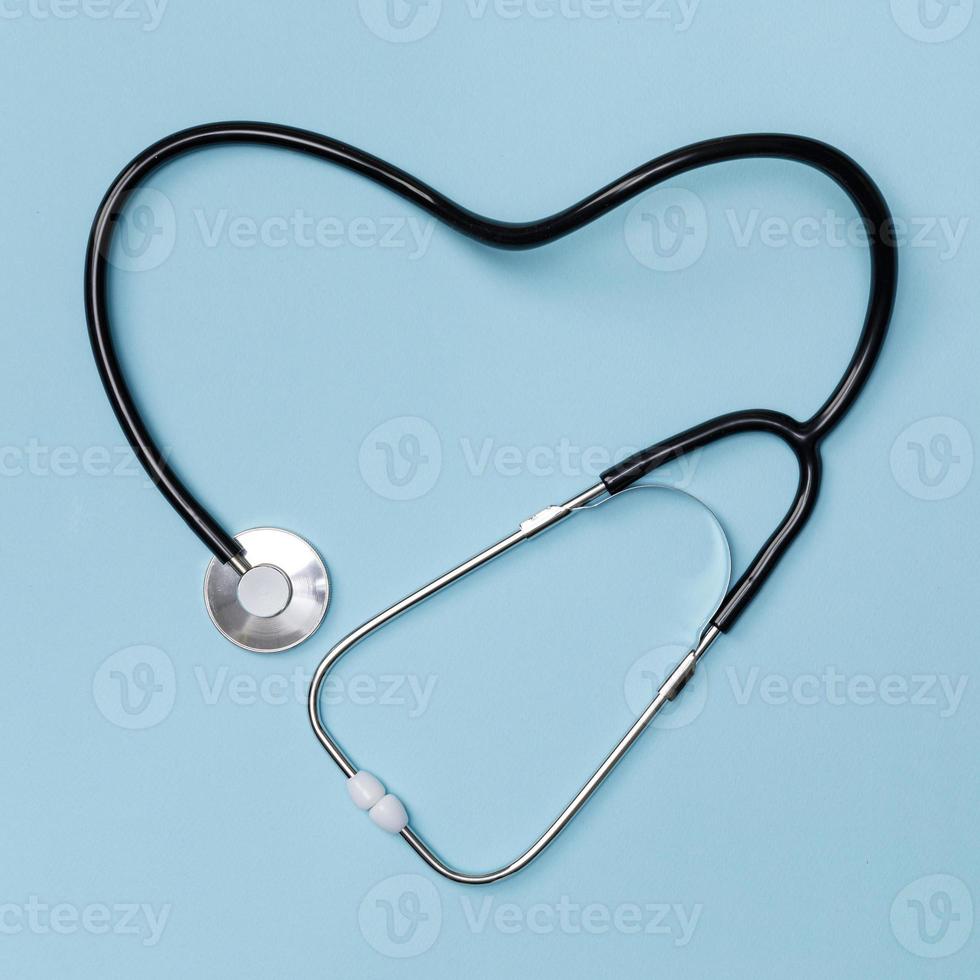 stéthoscope en forme de coeur sur fond de table bleu, bonne santé du concept de médecin, vue de dessus avec isolé sur bleu photo