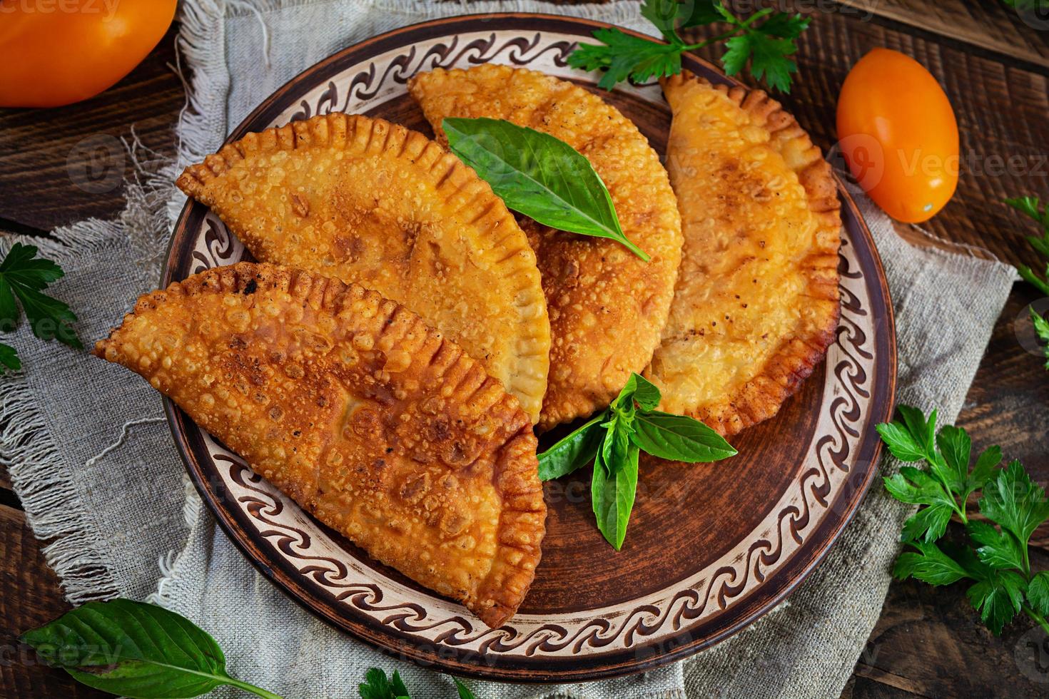 cuisine tatare de crimée traditionnelle, chebureki à la viande de poulet. empanadas frites sur fond de bois photo