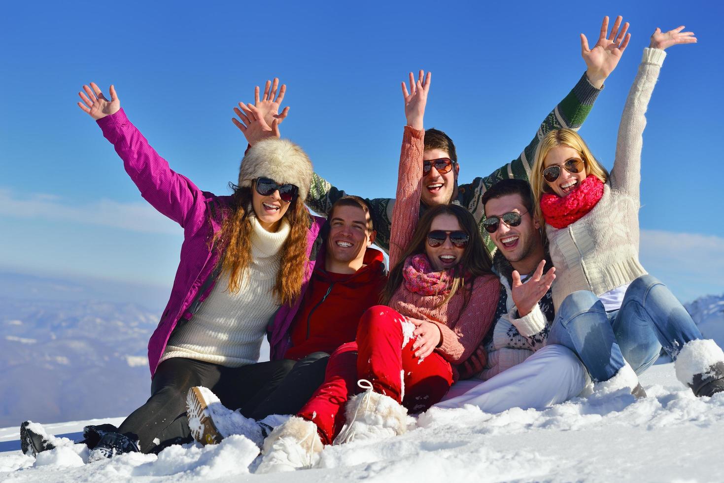 les amis s'amusent en hiver sur la neige fraîche photo