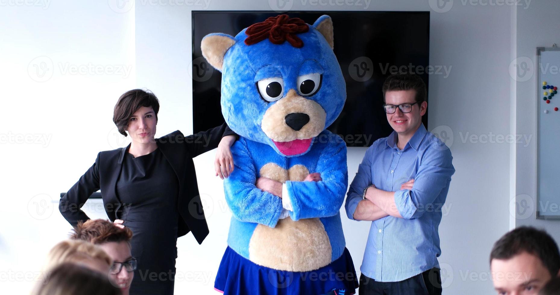 patron habillé en ours s'amusant avec des gens d'affaires dans un bureau branché photo