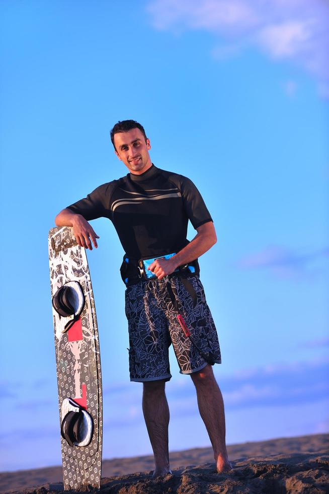 portrait d'un jeune homme kitsurf à la plage au coucher du soleil photo