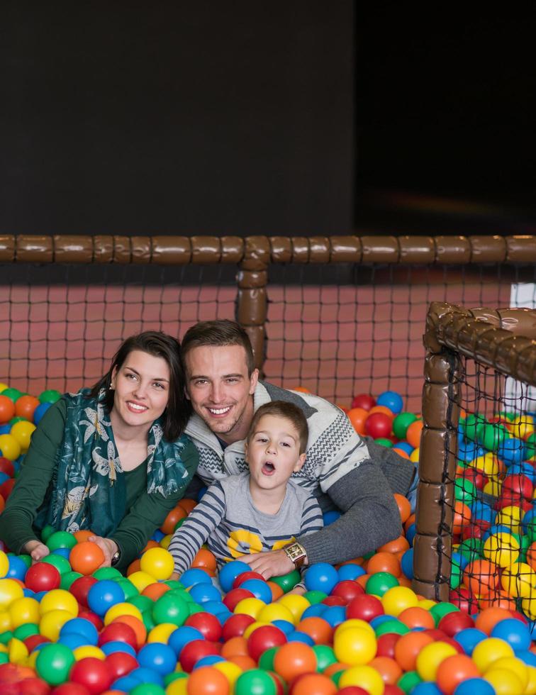 parents et enfants jouant dans la piscine avec des balles colorées photo