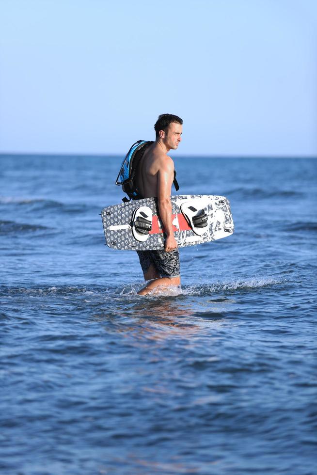 portrait d'un jeune homme kitsurf à la plage au coucher du soleil photo