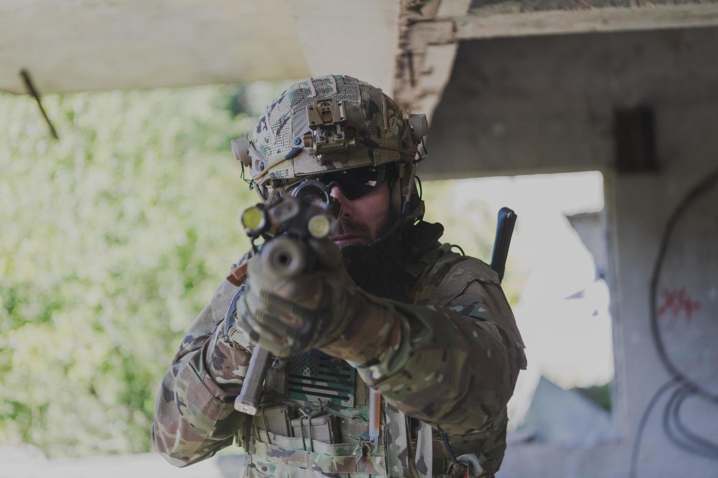 un soldat barbu en uniforme des forces spéciales dans une action militaire dangereuse dans une zone ennemie dangereuse. mise au point sélective photo