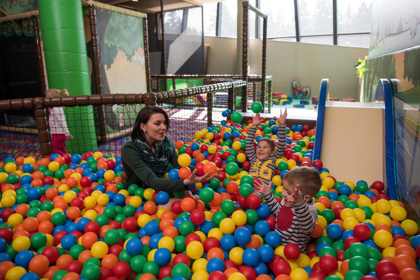 jeune maman avec ses enfants dans une salle de jeux pour enfants photo