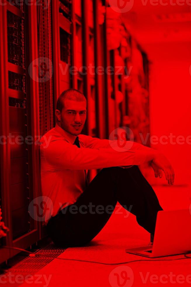 homme d'affaires avec ordinateur portable dans la salle des serveurs réseau photo