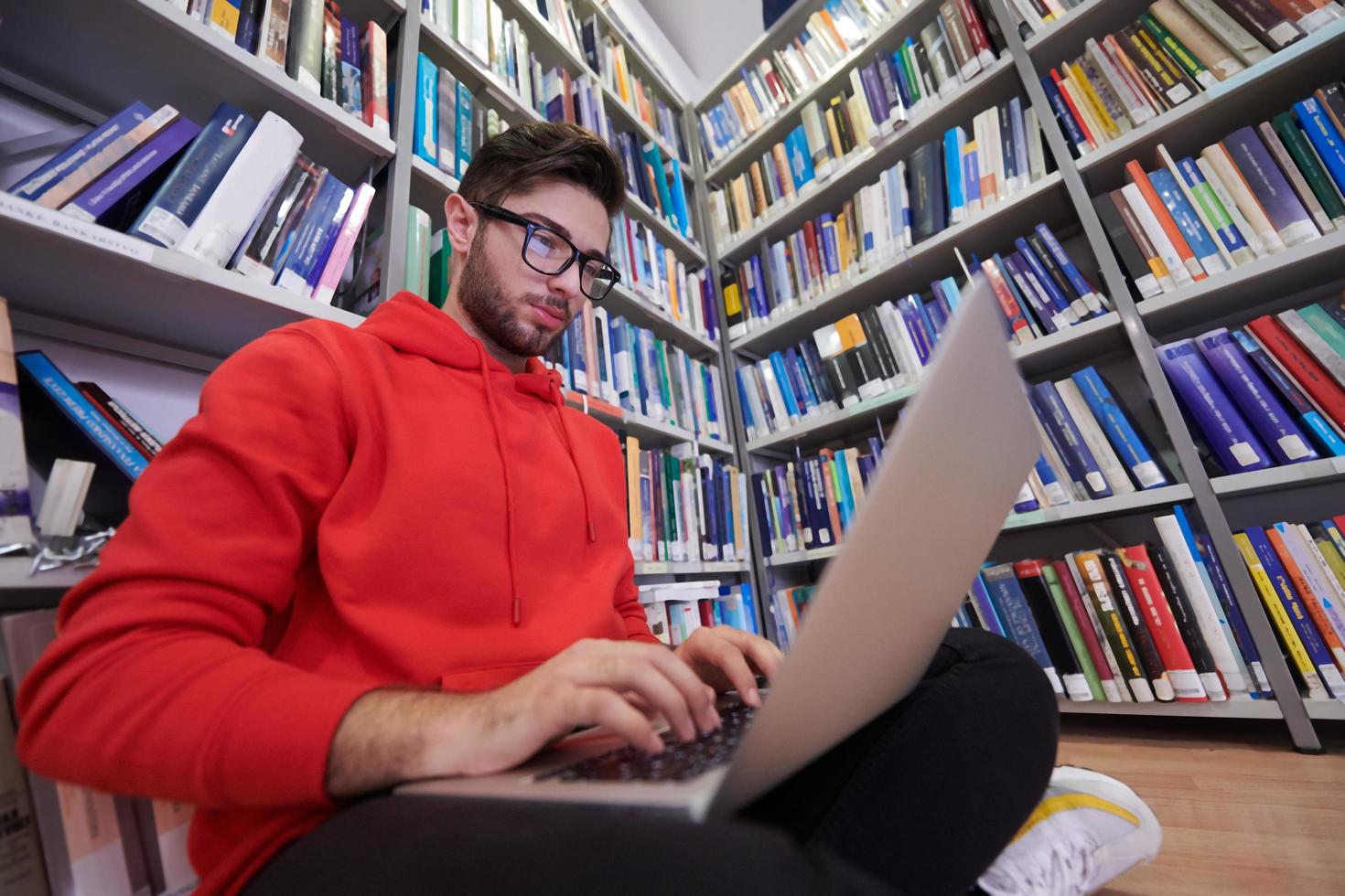 les élèves utilisent un cahier, un ordinateur portable et une bibliothèque scolaire photo