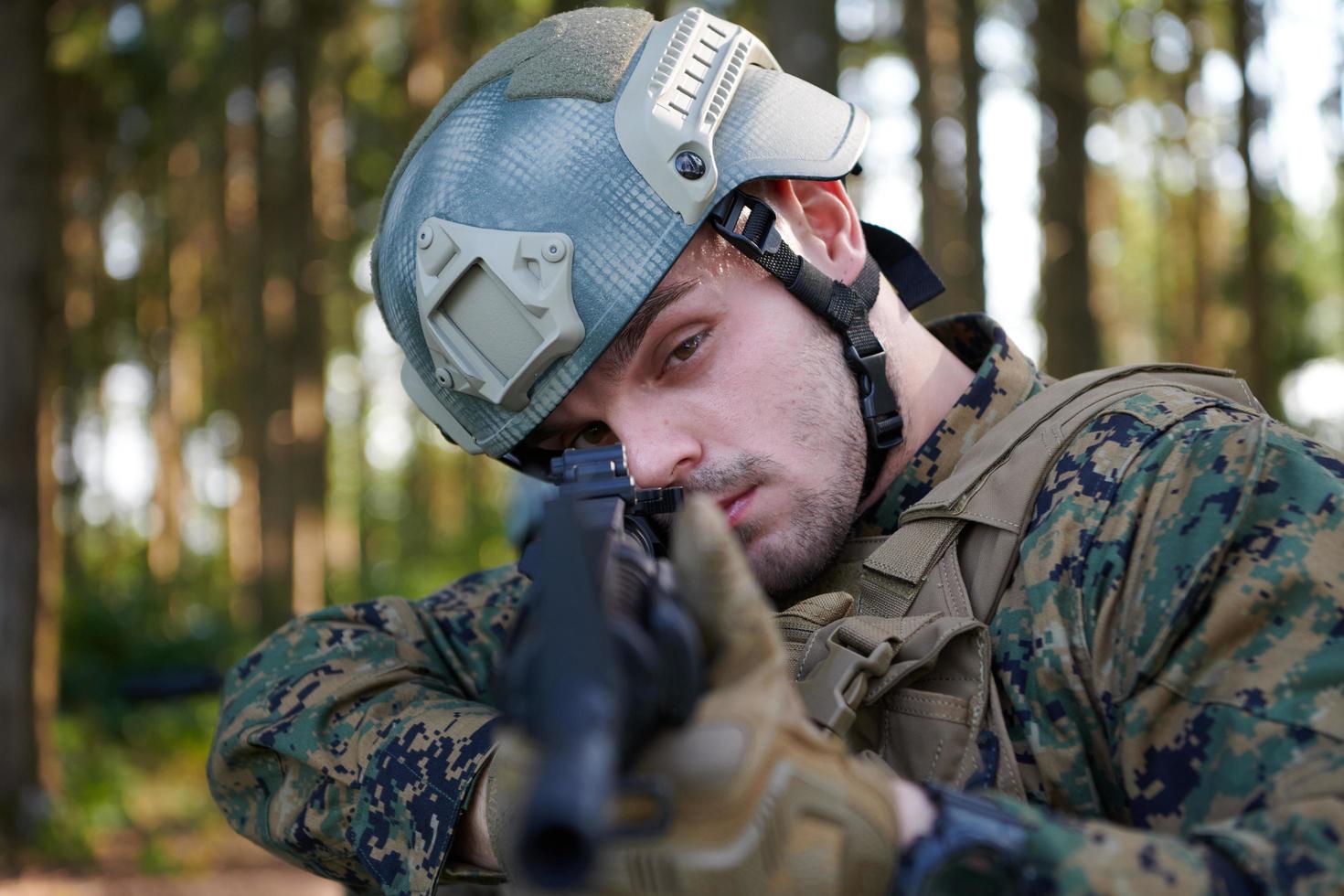 Soldat en action visant l'optique de visée laser de l'arme photo