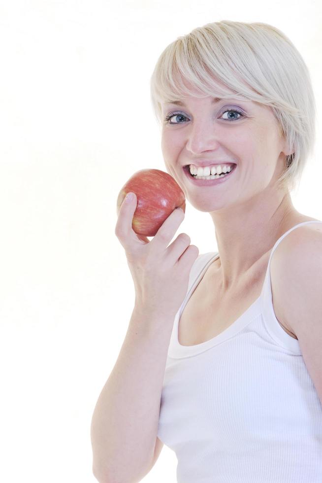 heureuse jeune femme mange une pomme verte isolée sur blanc photo