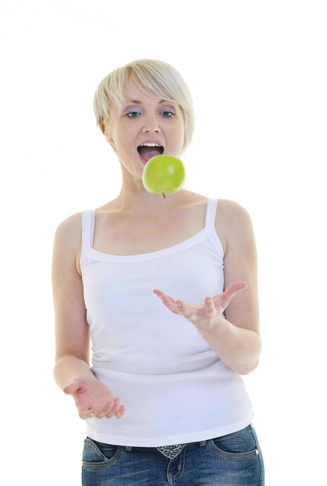 heureuse jeune femme mange une pomme verte isolée sur blanc photo