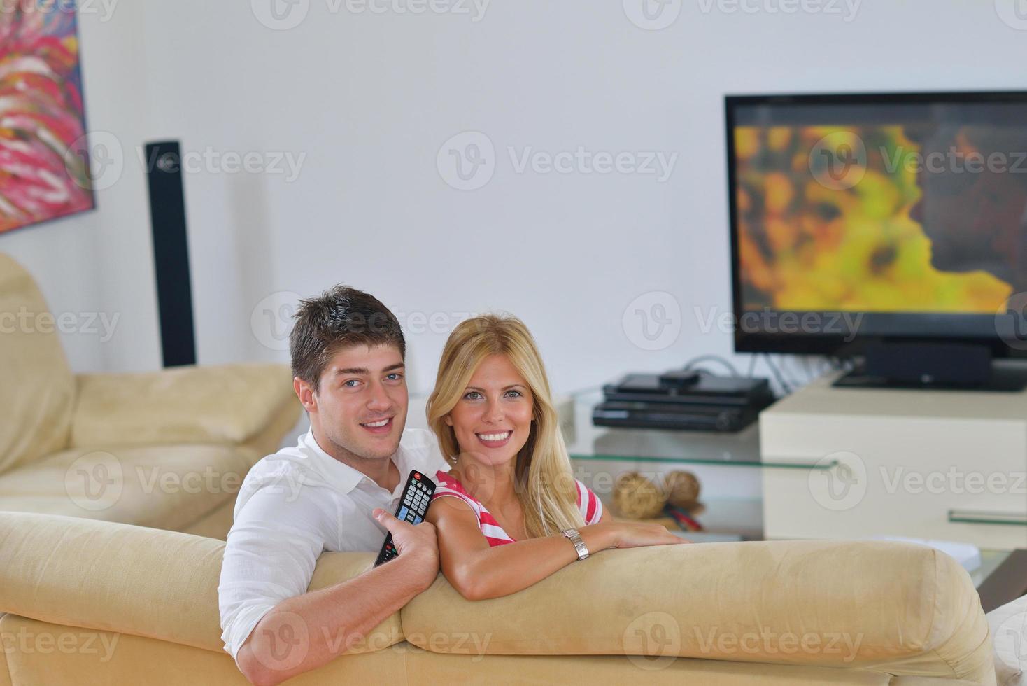 jeune couple détendu devant la télé à la maison photo