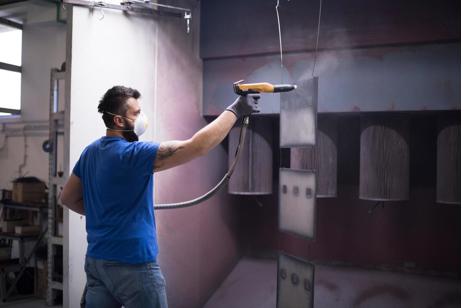 le peintre peint l'élément de fer. pièces de peinture industrielle. dessins en métal photo