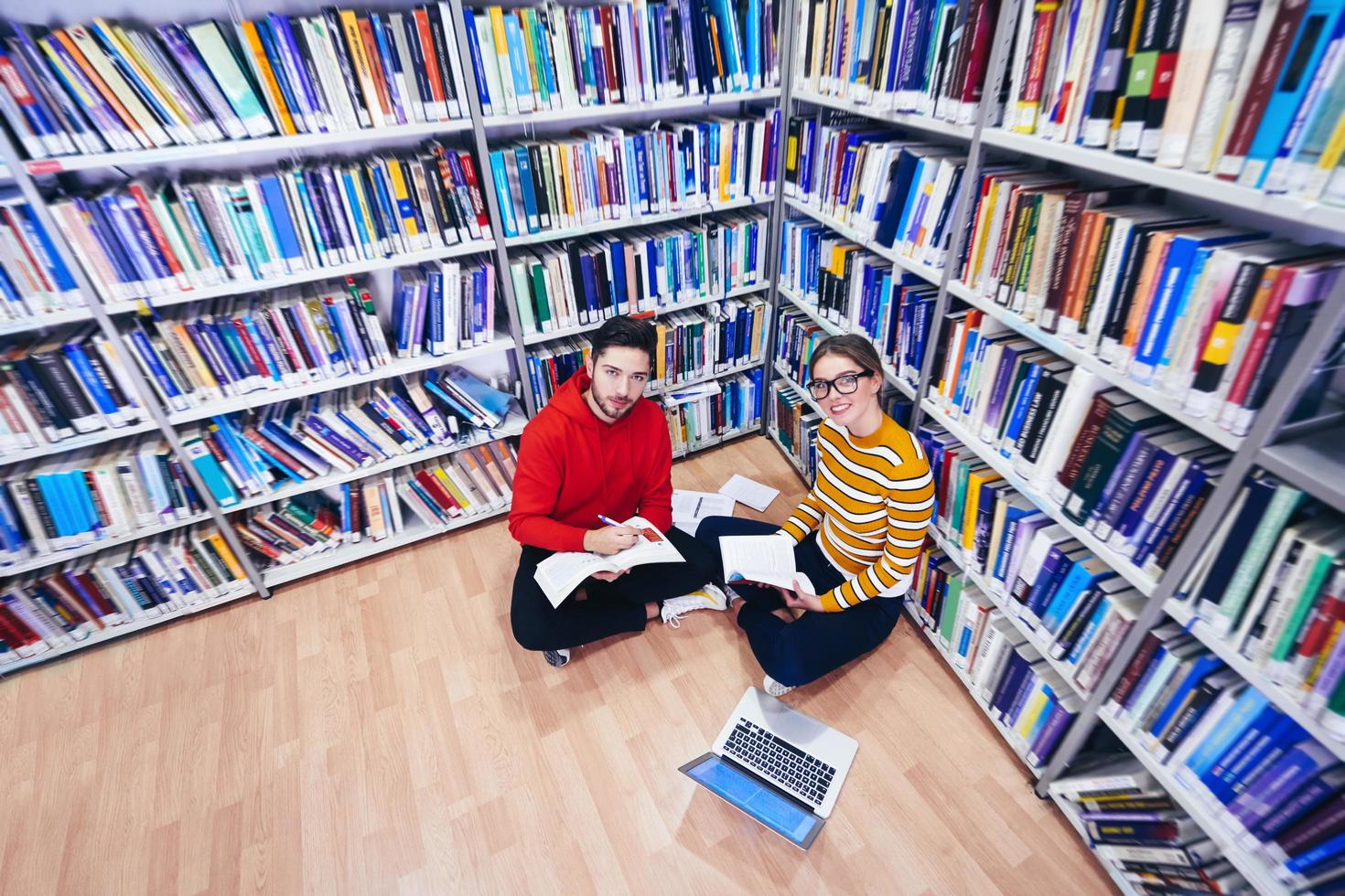 les élèves utilisent un cahier, un ordinateur portable et une bibliothèque scolaire photo