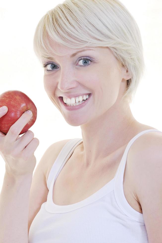 heureuse jeune femme mange une pomme verte isolée sur blanc photo