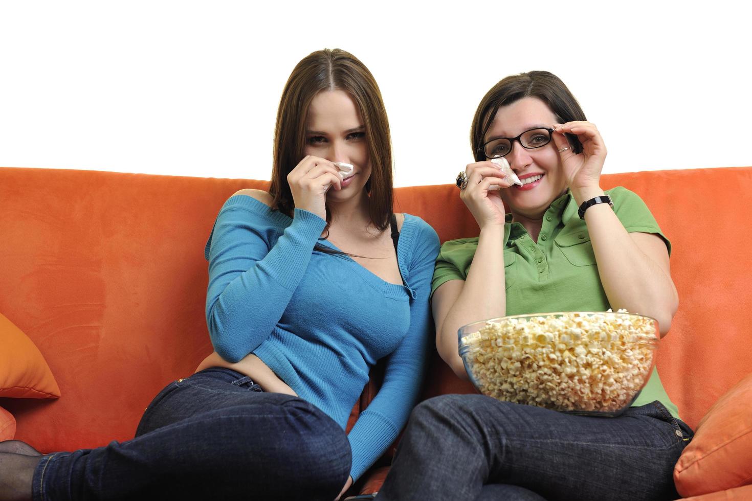 Amies manger du pop-corn et regarder la télévision à la maison photo