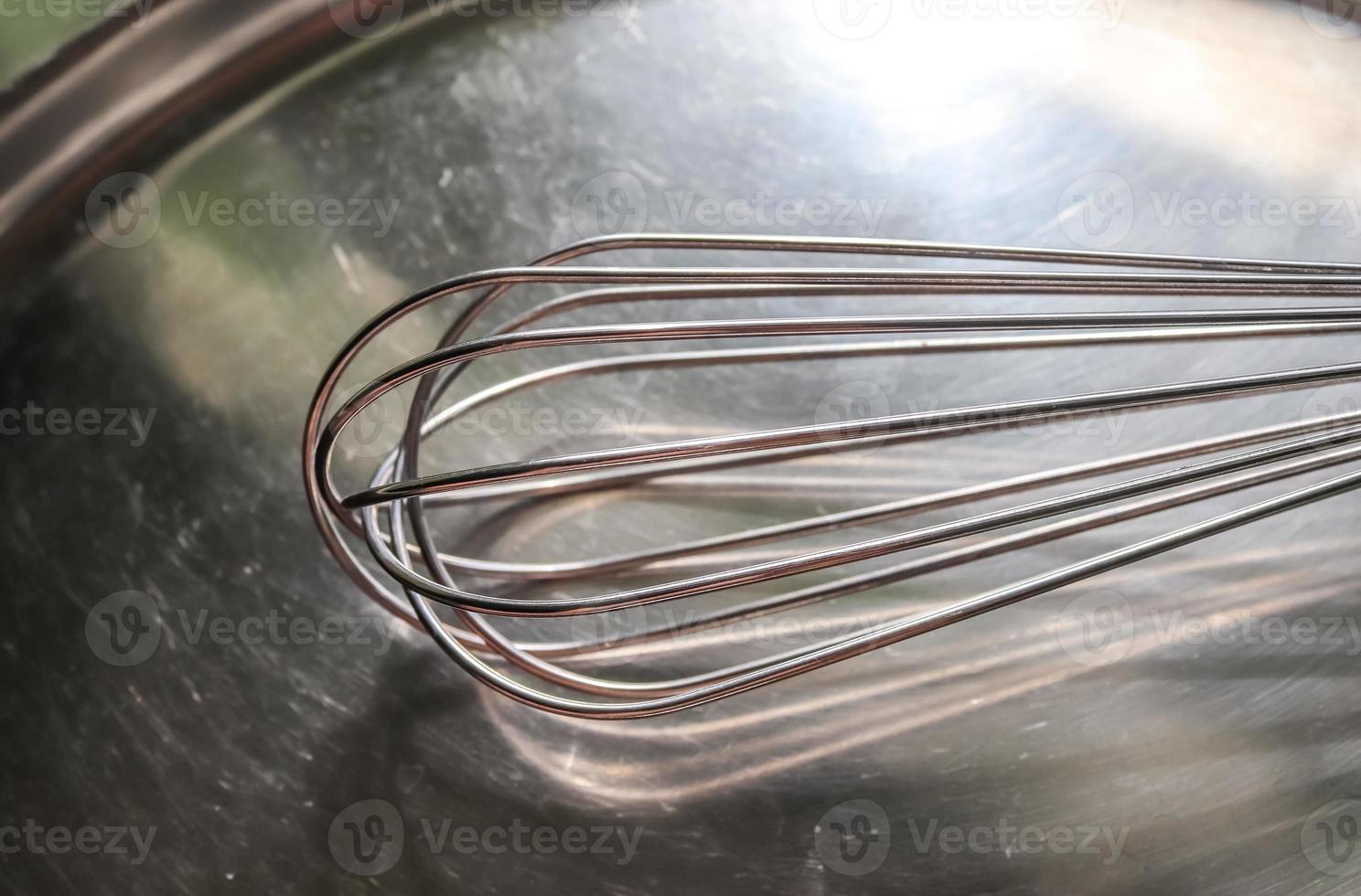 batteur à main manuel pour mélanger, battre, batteur à oeufs isolé sur fond métallique. Ustensile de cuisine en métal en acier inoxydable. photo