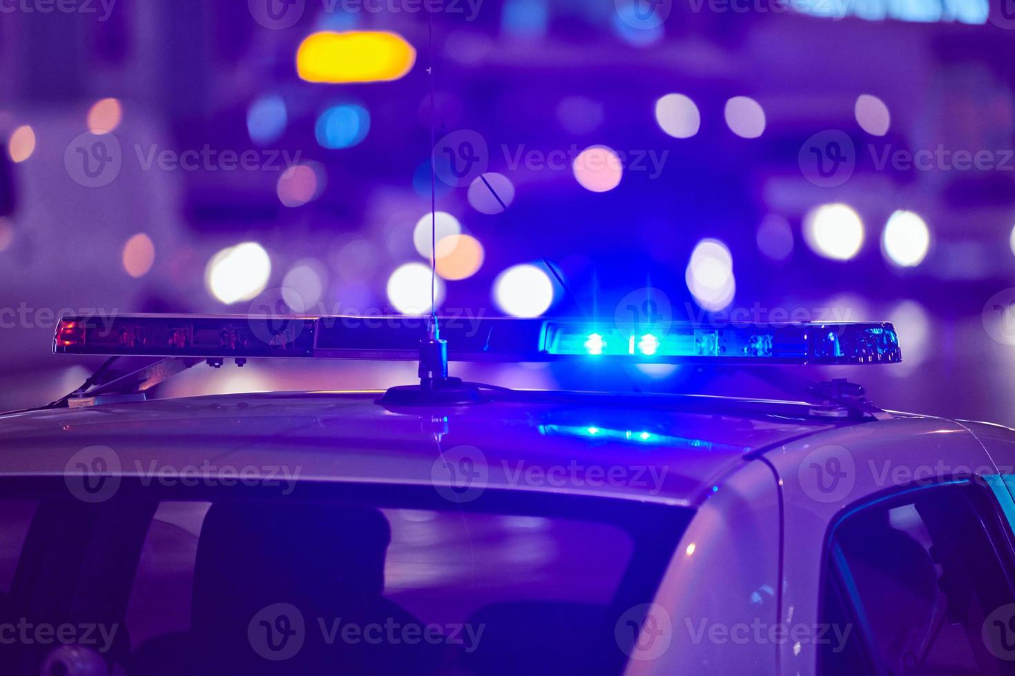 voiture de police s'allume la nuit rue de la ville photo