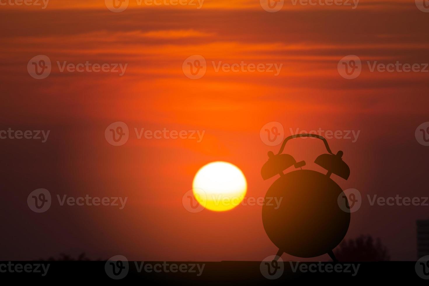 horloge silhouette au lever du soleil photo