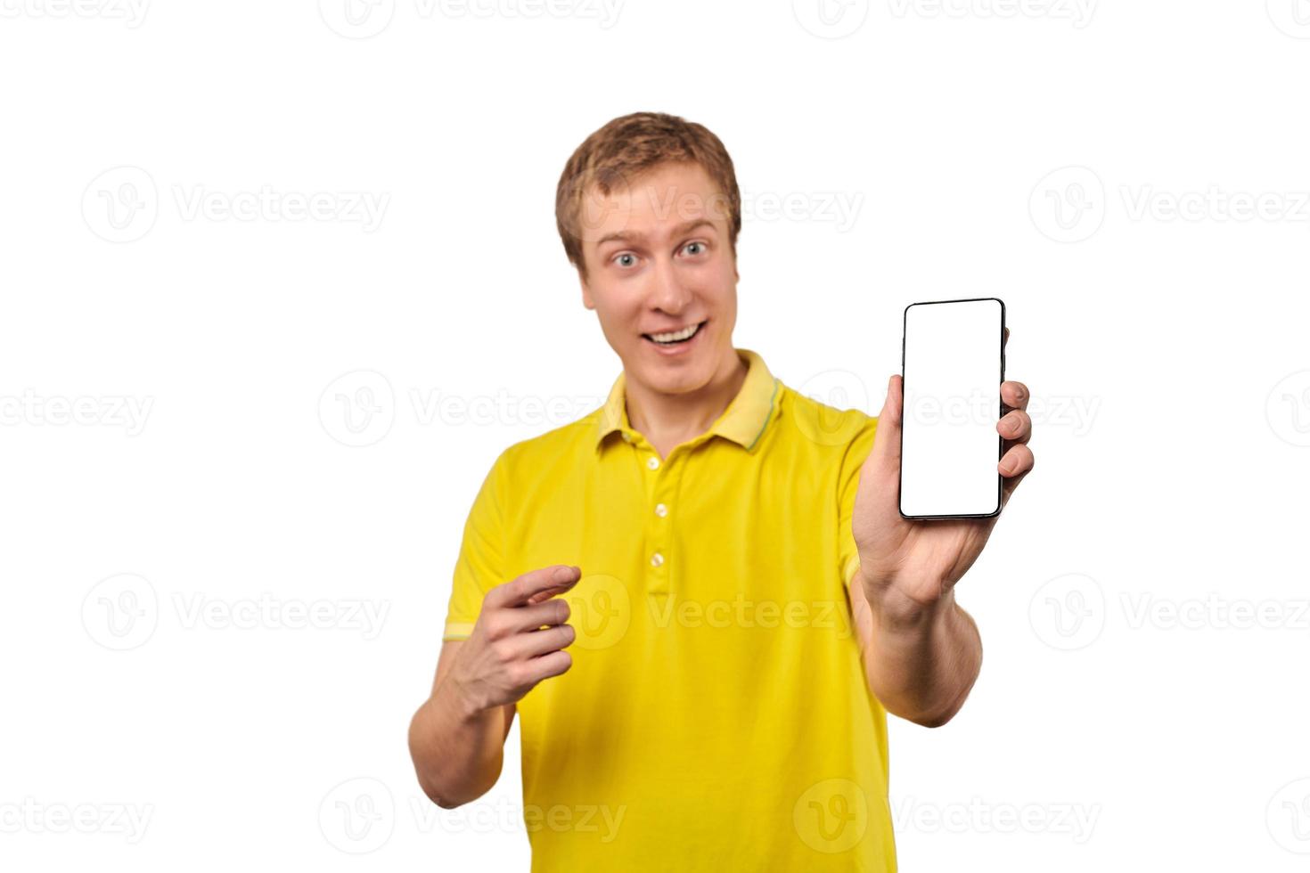 jeune homme souriant avec maquette de smartphone à la main, arrière-plan blanc isolé, publicité pour application mobile photo