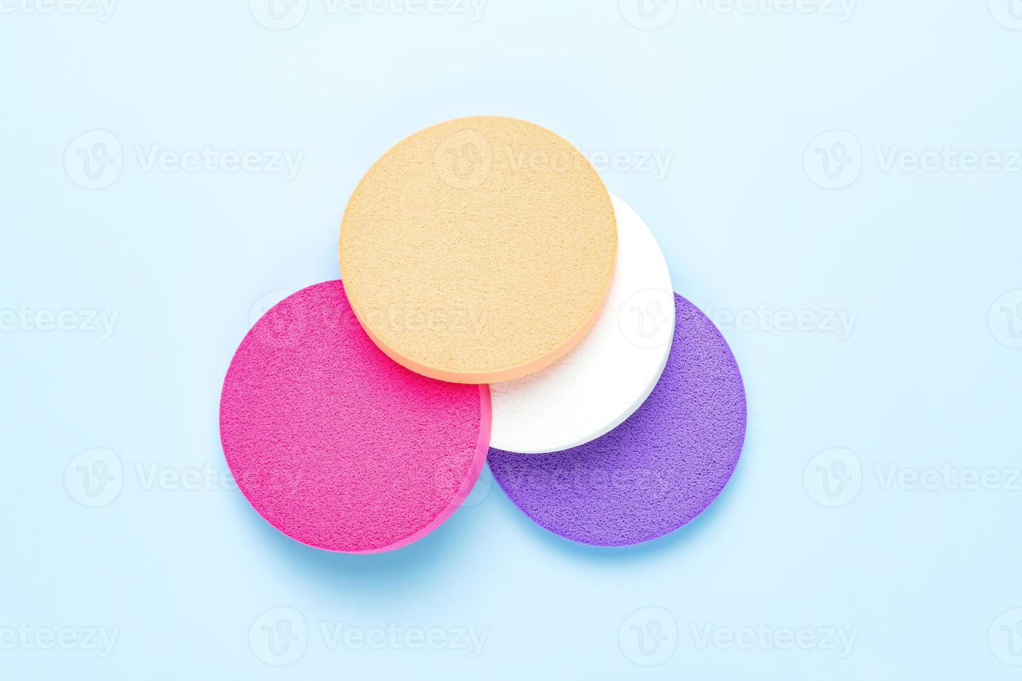 ensemble d'éponges de maquillage rondes multicolores pour fond de teint liquide appliquant une correction naturelle de la peau. produit pour le visage. photo