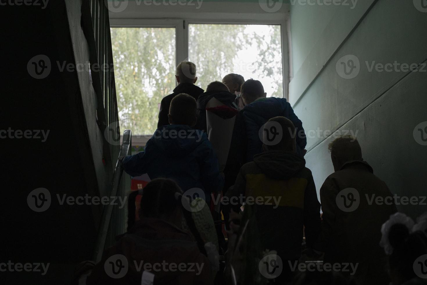 les écoliers montent les escaliers. enfants dans le bâtiment de l'école. les élèves montent en classe. photo