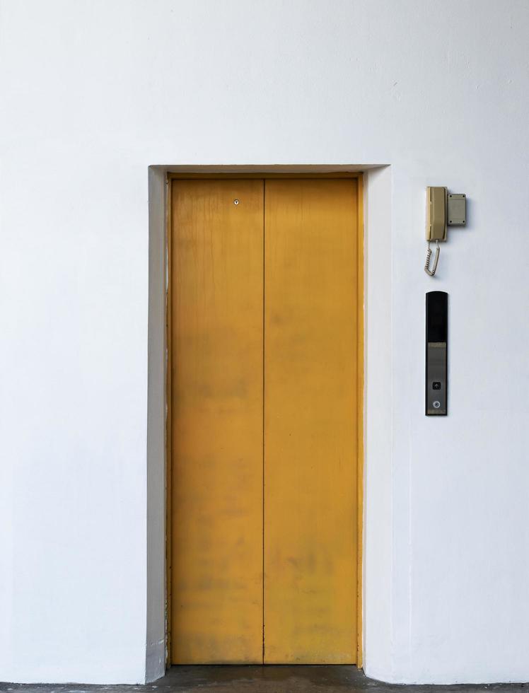 Ascenseur jaune porte fermée avec fond de mur blanc photo