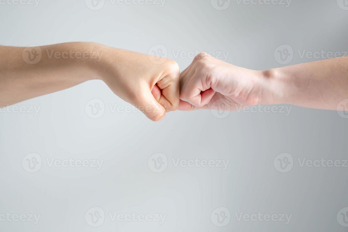 le symbole de la main de deux poings s'écrasent ensemble sur fond blanc. photo