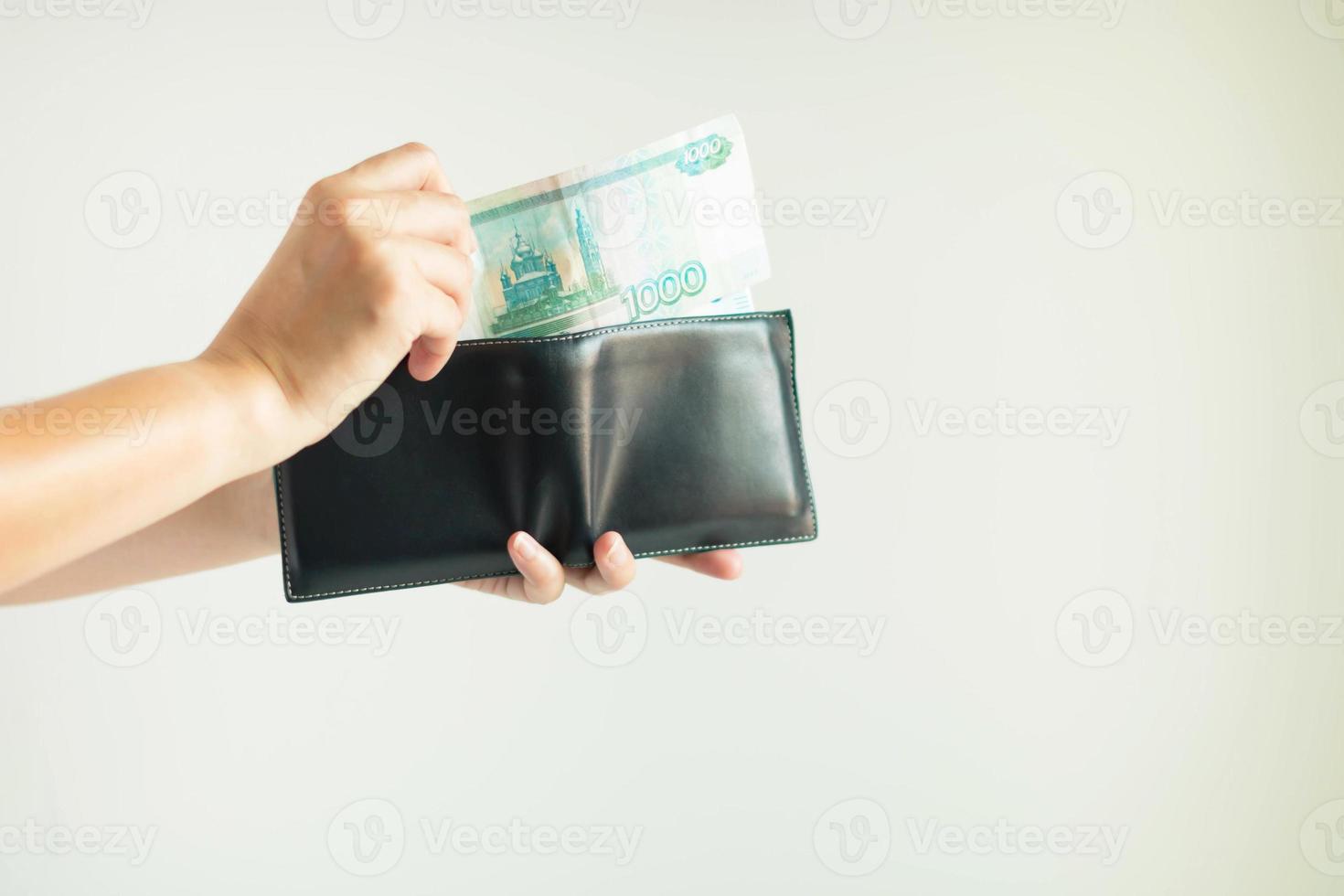 mains cueillant de l'argent en rouble dans le portefeuille court pour le paiement en fédération de russie. photo