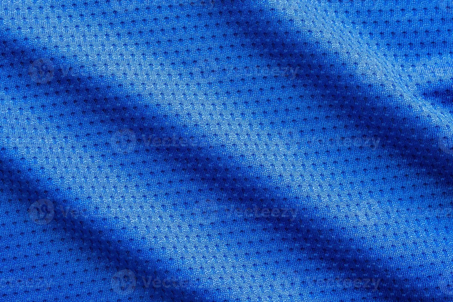 maillot de football de vêtements de sport en tissu de couleur bleue avec fond de texture en maille d'air photo